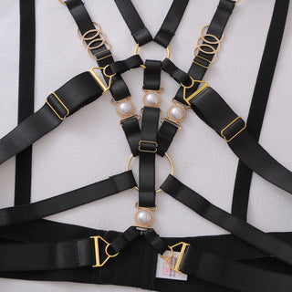 Close view of the pearl and gold-tone fittings on the black straps