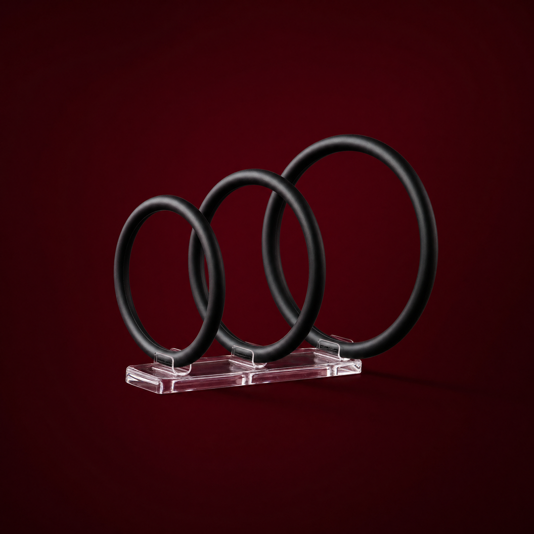 Esme three-pack of black silicone rings on a burgundy studio background