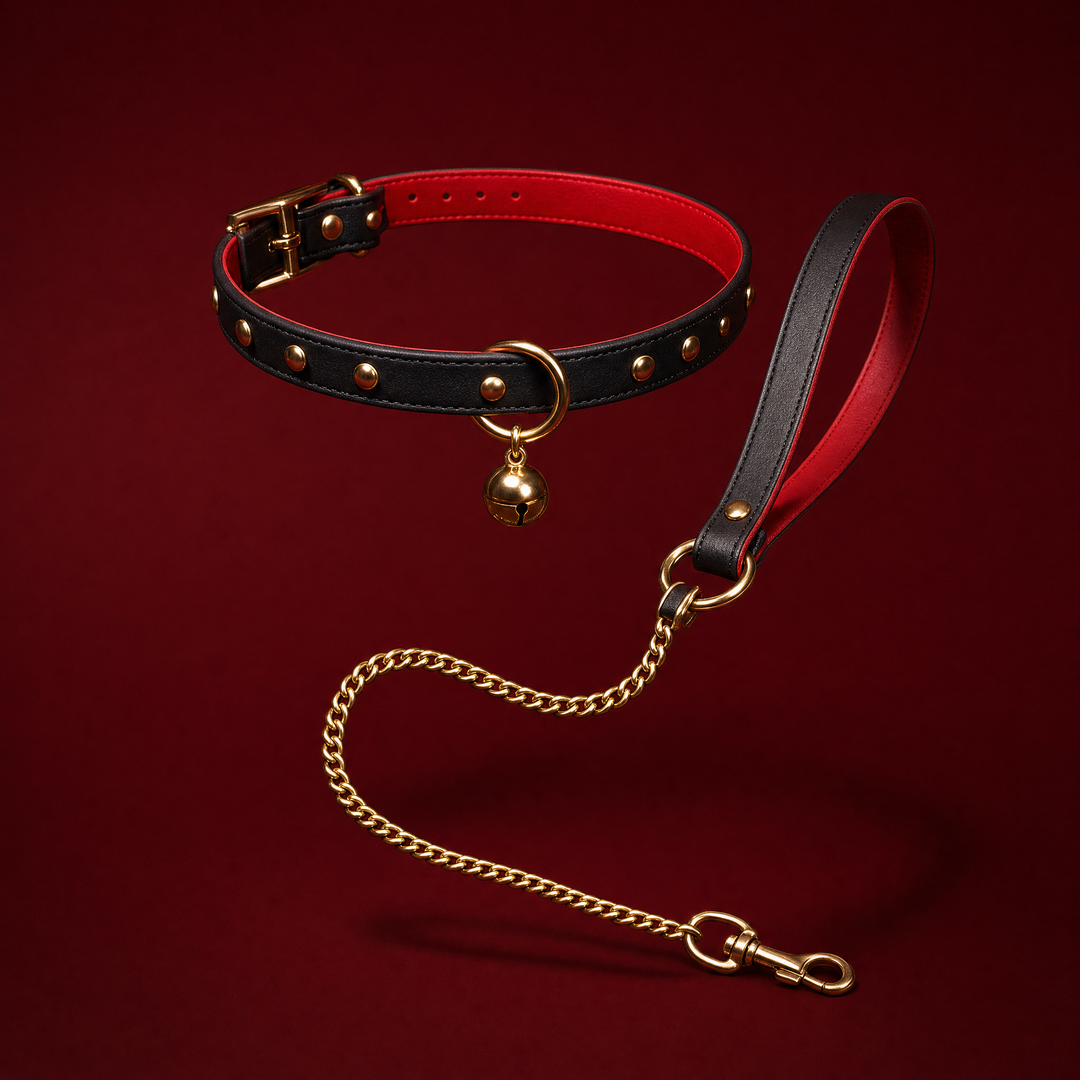 Clemence bell collar with gold chain leash on a deep burgundy studio background