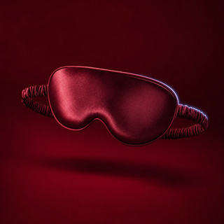Eloise padded satin blindfold in wine red with a gathered elastic band, on a deep burgundy background
