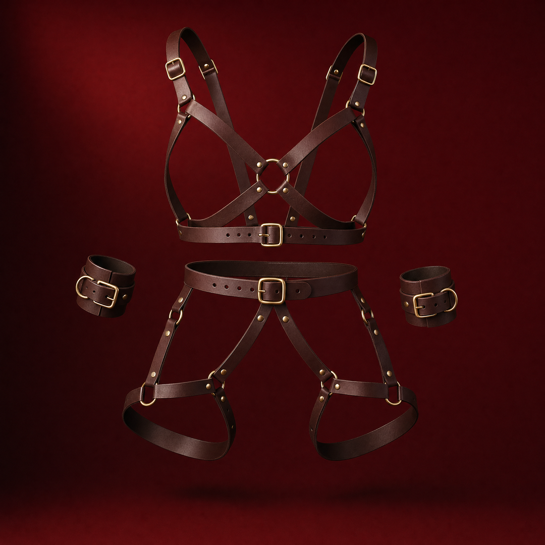 Imogen brown strap body harness set with gold rings and buckles and matching wrist cuffs, on a deep burgundy background