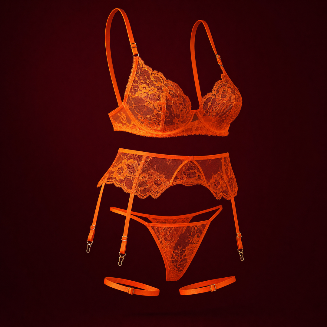 Isadora neon orange lace bra, garter belt, thong and thigh bands on a deep burgundy studio background