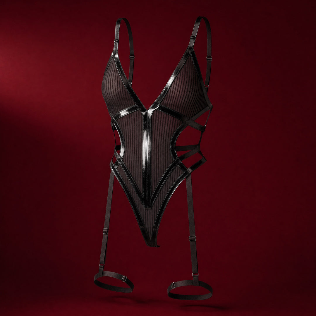 Tatienne black striped mesh teddy bodysuit with glossy V binding and suspender straps running to thigh bands, on a deep burgundy studio background